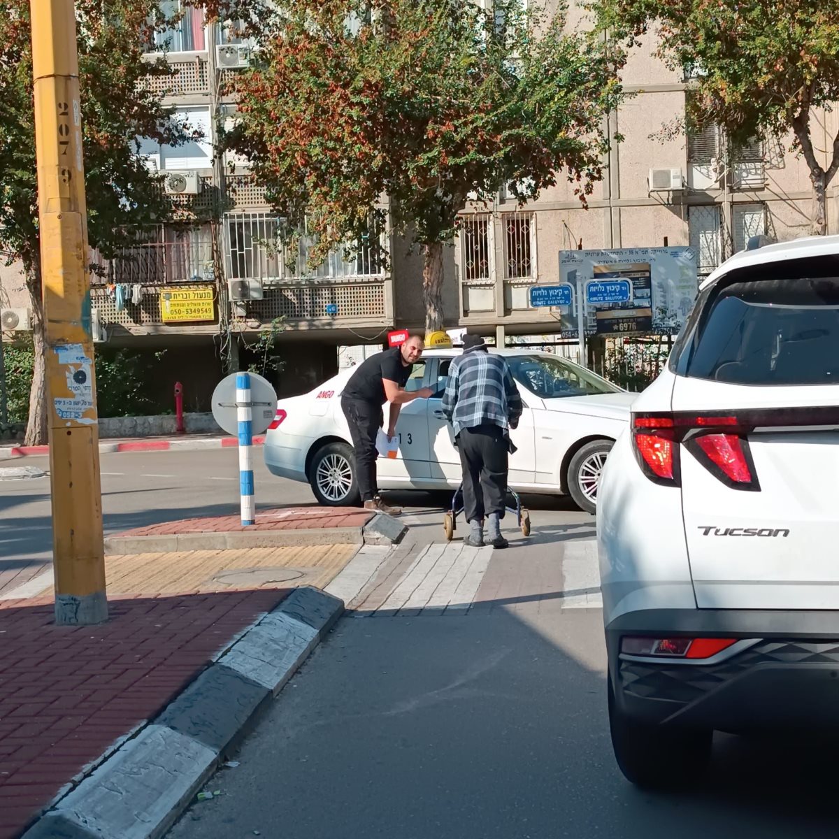 הצעיר מכניס את הקשיש למונית שעליה שילם מיוזמתו. מאיר אוליאל