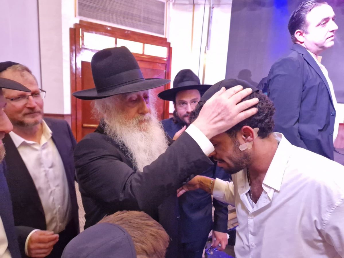 האדמור רבי דוד פינטו מברך את אחד הניצולים. א&#39; מיכאלי