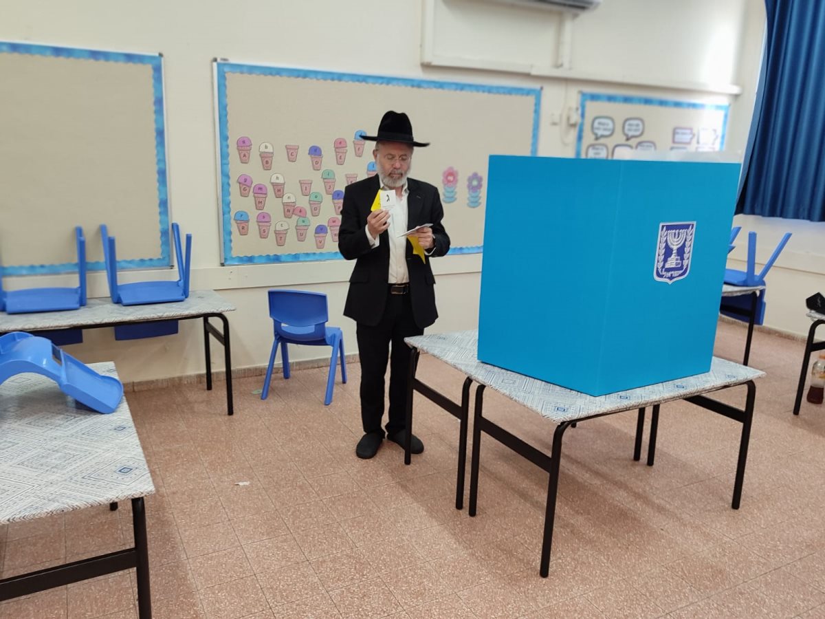 הרב עזרא שור מצביע. המצלם