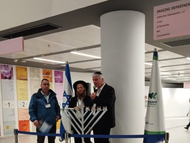 אבי אמסלם מדליק נרות באסותא. המצלם