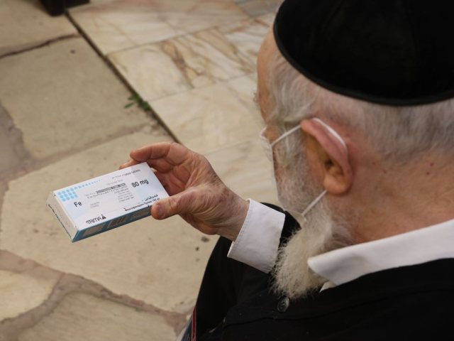 הגאון הגדול רבי יצחק זילברשטיין שליט"א מעיין במדבקה החדשנית על קופסת התרופה בשנת תשפ"ב